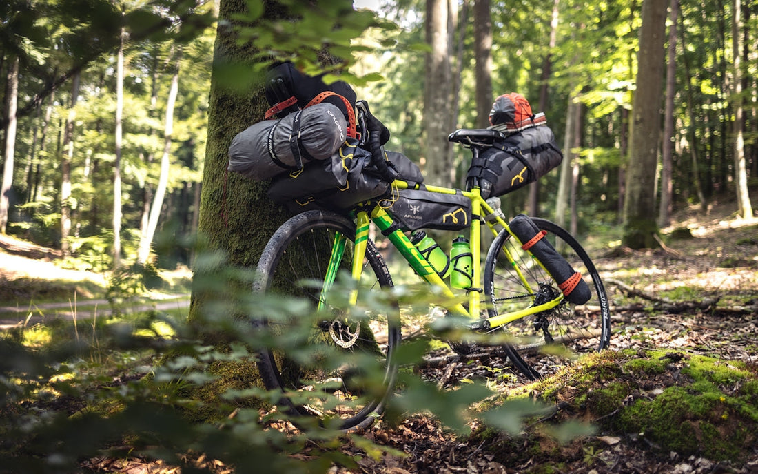Mann in schwarzer Jacke und mit schwarzem Rucksack fährt auf einem grünen Fahrrad.