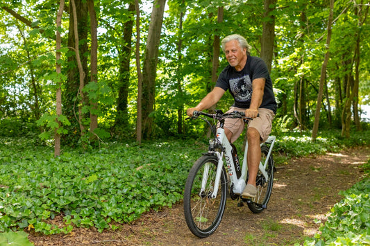 ein Mann, der mit dem Fahrrad durch einen sattgrünen Wald fährt