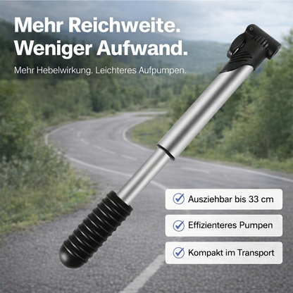 Ausziehbare Mini-Fahrradpumpe mit verlängertem Pumpenkörper vor Straßenkulisse dargestellt.